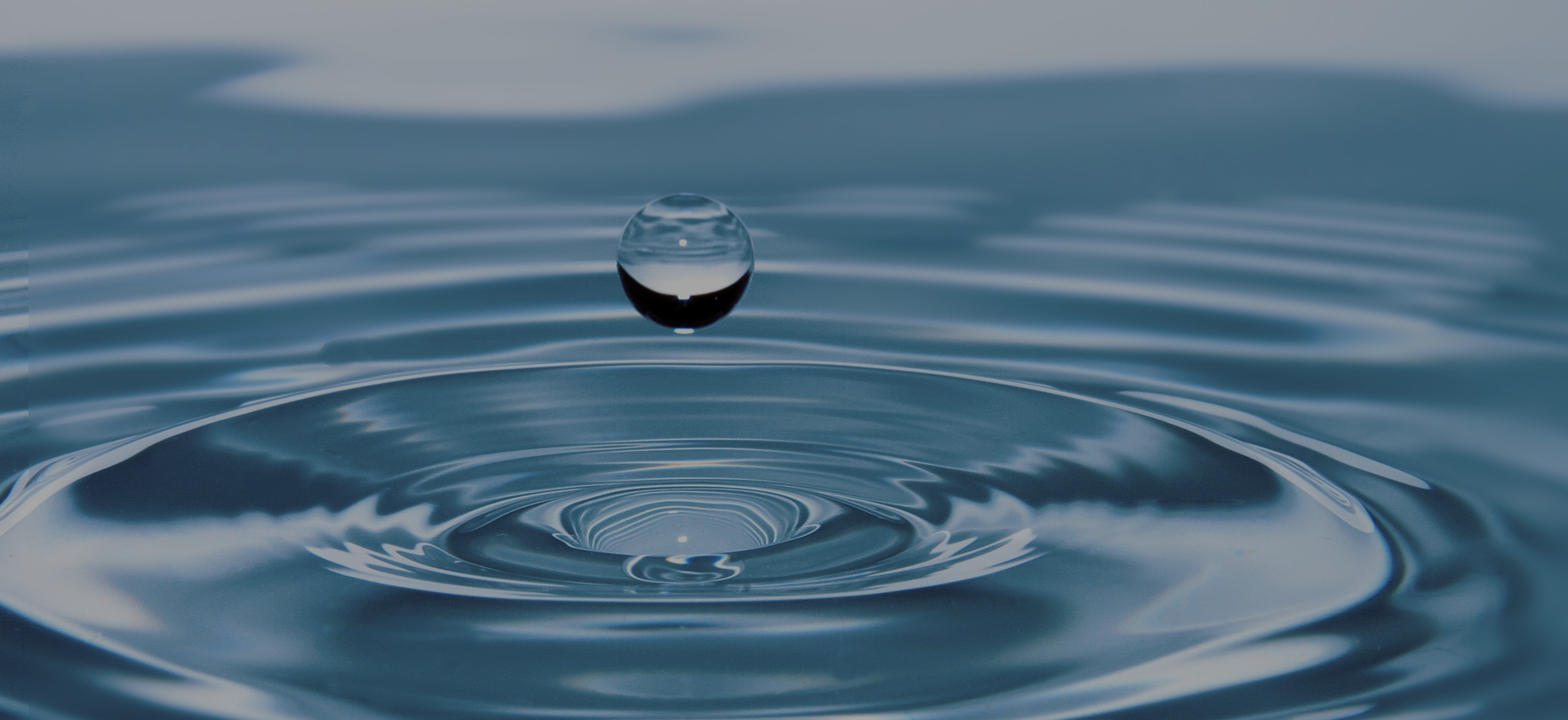Wassertropfen auf einer ruhigen Wasseroberfläche